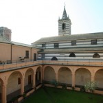 La bellezza del Chiostro con il dettaglio del campanile a strisce bianche e nere della Chiesa di San Giorgio